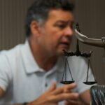 image of scales of justice in front of talking man